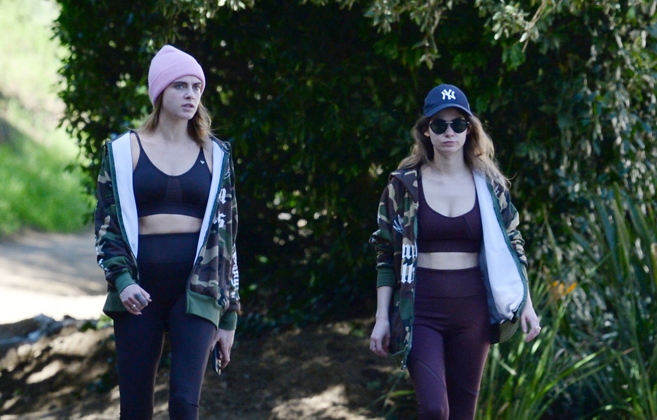 Model and actress, Cara Delevingne, walks happily with her girlfriend through the streets of Los Angeles